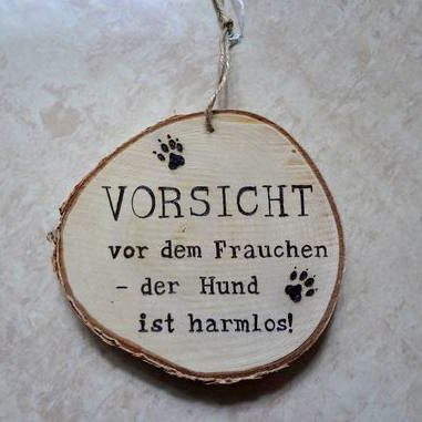 Holzschild mit der Aufschrift: "Vorsicht vor dem Frauchen - der Hund ist harmlos!"