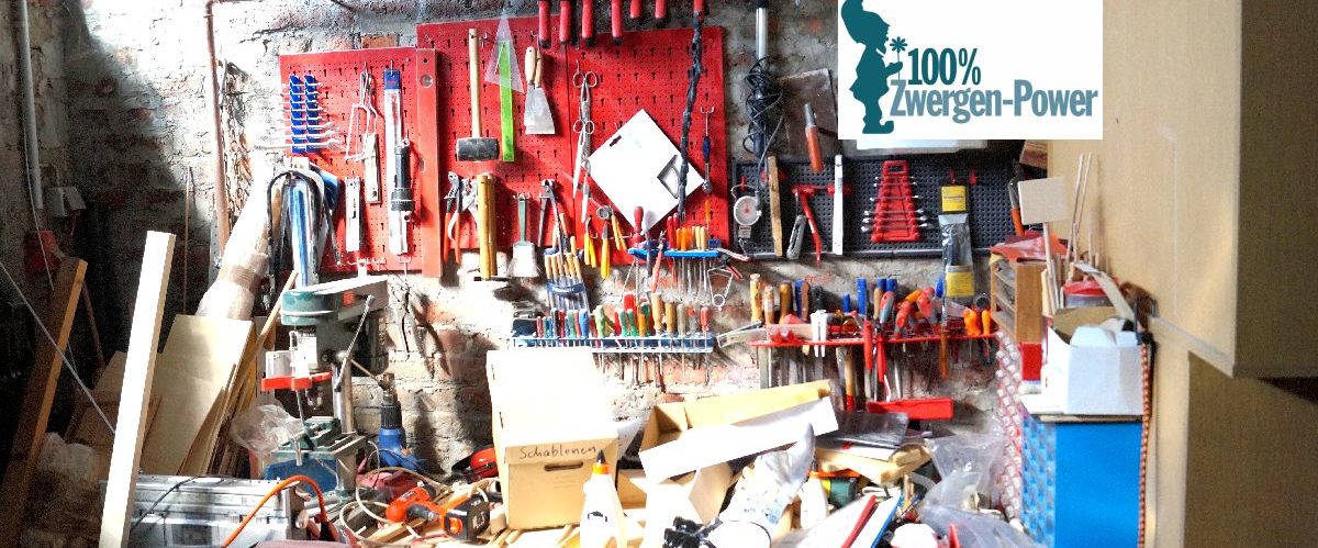 Zwergen-POWER Werkstatt mit zahlreichen Werkzeugen und Materialien auf einem Tisch.